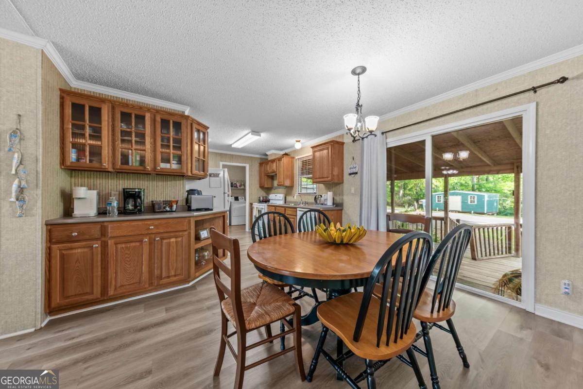 194 Phillips Road Eatonton, GA 31024 - Photo 12 of 57 a dining room with furniture a chandelier and wooden floor
