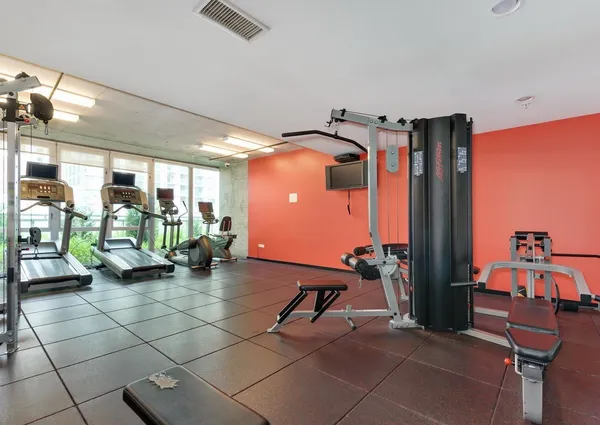 a room with gym equipment and large mirror