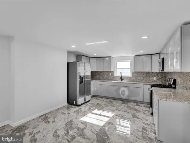 a kitchen with stainless steel appliances granite countertop a refrigerator sink and cabinets