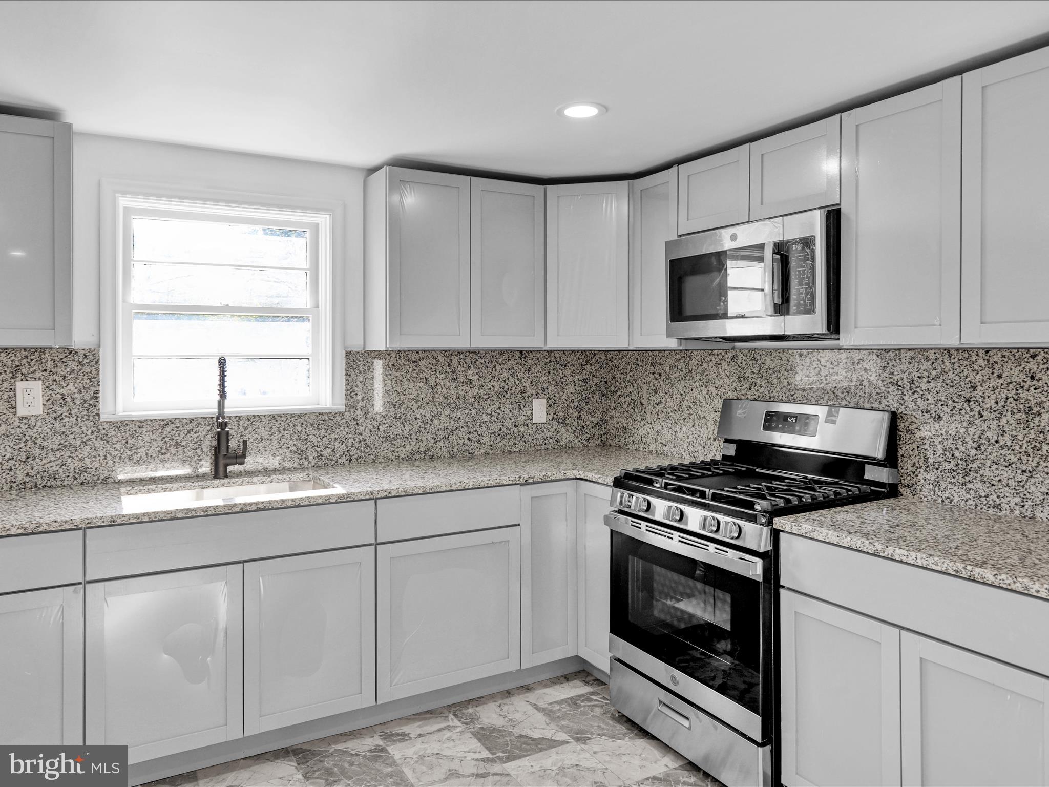 320 Hillside Drive Reading, PA 19607 - Photo 18 of 38 a kitchen with granite countertop a stove sink and cabinets
