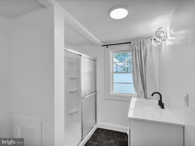 a bathroom with a sink a window and a mirror