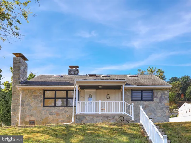 a view of a big house with a big yard and large tree