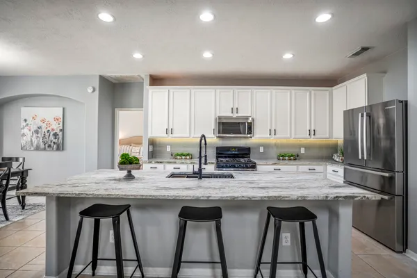 a kitchen with stainless steel appliances granite countertop a stove a sink dishwasher a refrigerator a microwave oven with granite countertops and cabinets