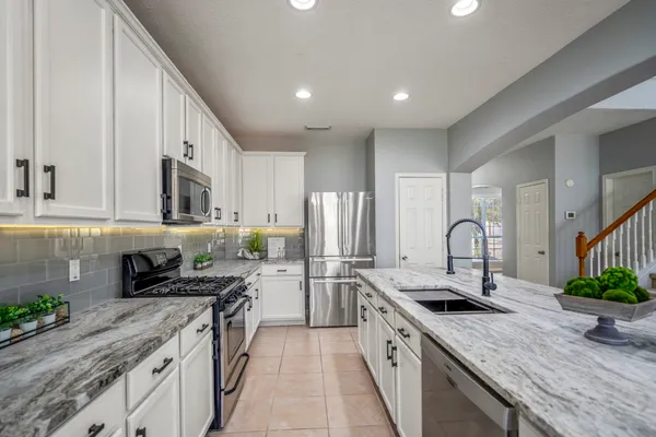 a kitchen with stainless steel appliances granite countertop a sink stove and refrigerator