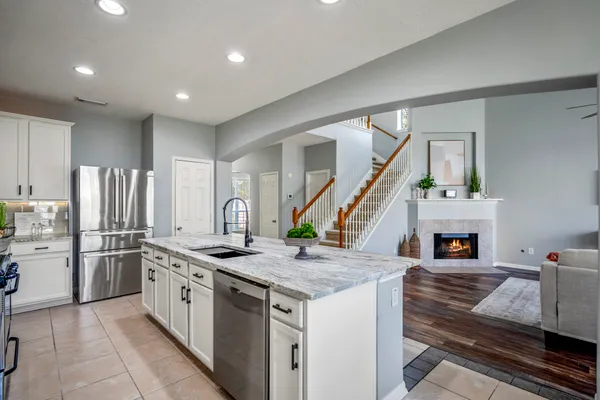 a kitchen with stainless steel appliances granite countertop a stove refrigerator and a fireplace