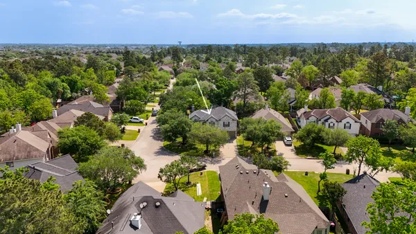 an aerial view of residential houses with outdoor space and trees