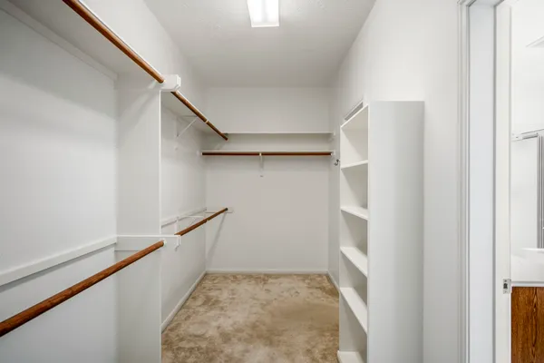 a view of walk in closet with empty racks