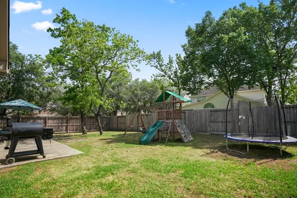 a view of a backyard with a table and a large tree