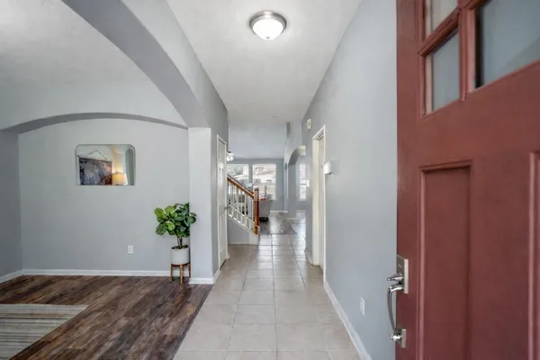 a view of a hallway with wooden floor and a potted plant
