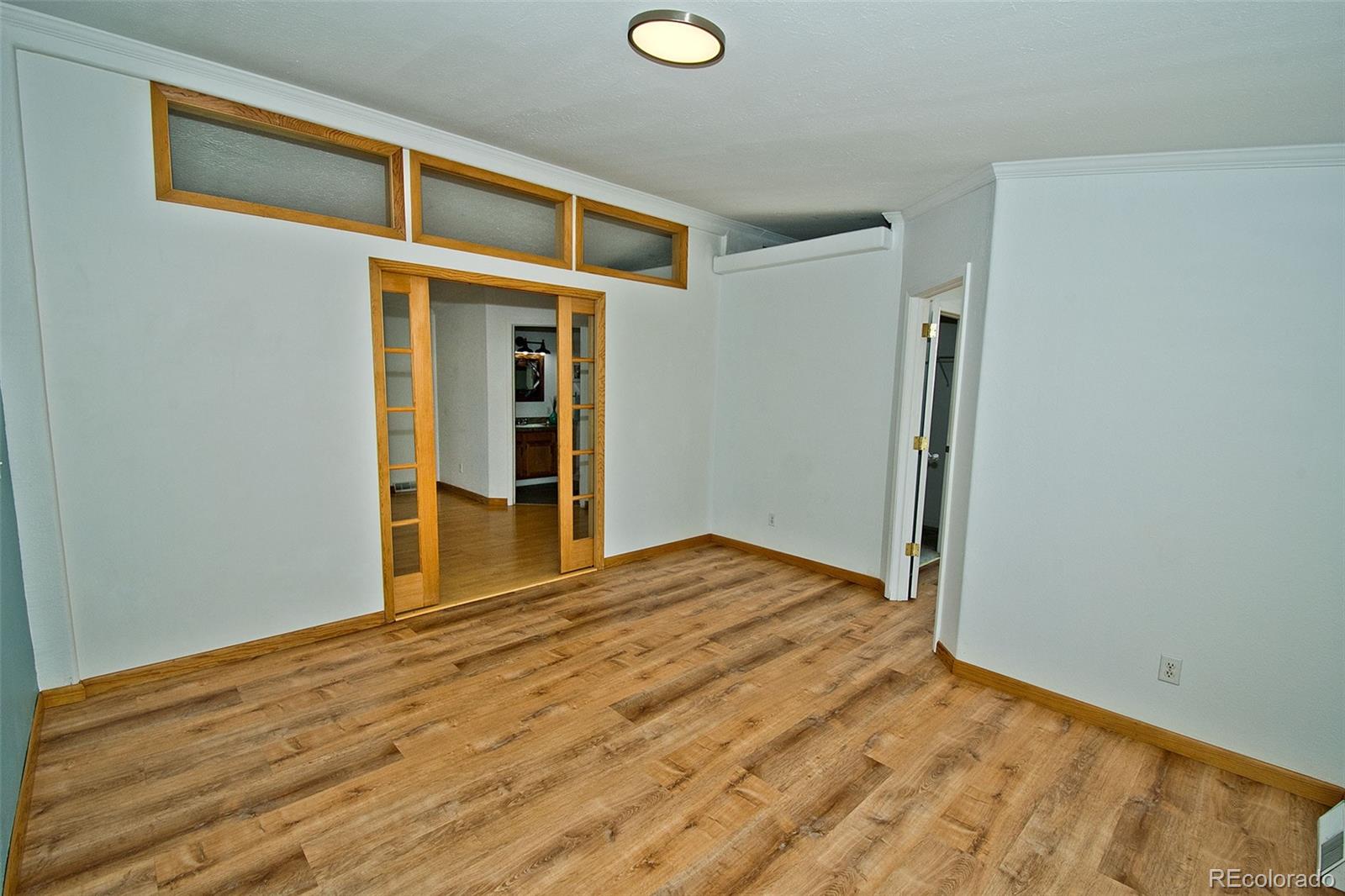 1372 North Saddlerock Trail Crestone, CO 81131 - Photo 23 of 43 a view of an empty room with wooden floor and a window