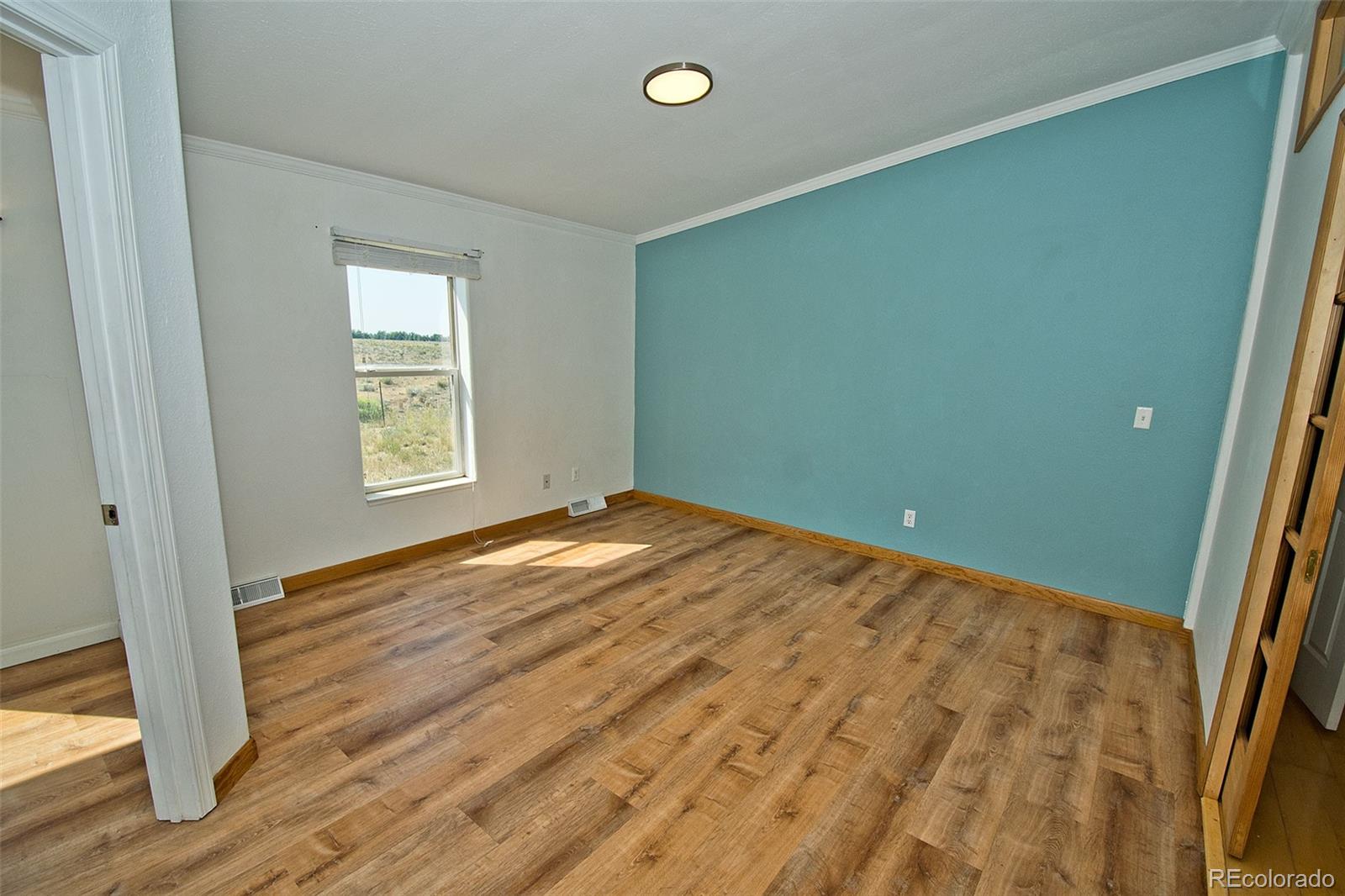 1372 North Saddlerock Trail Crestone, CO 81131 - Photo 24 of 43 a view of empty room with wooden floor and fan