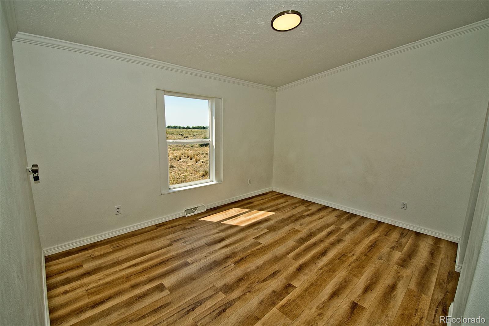 1372 North Saddlerock Trail Crestone, CO 81131 - Photo 40 of 43 a view of empty room with wooden floor and fan