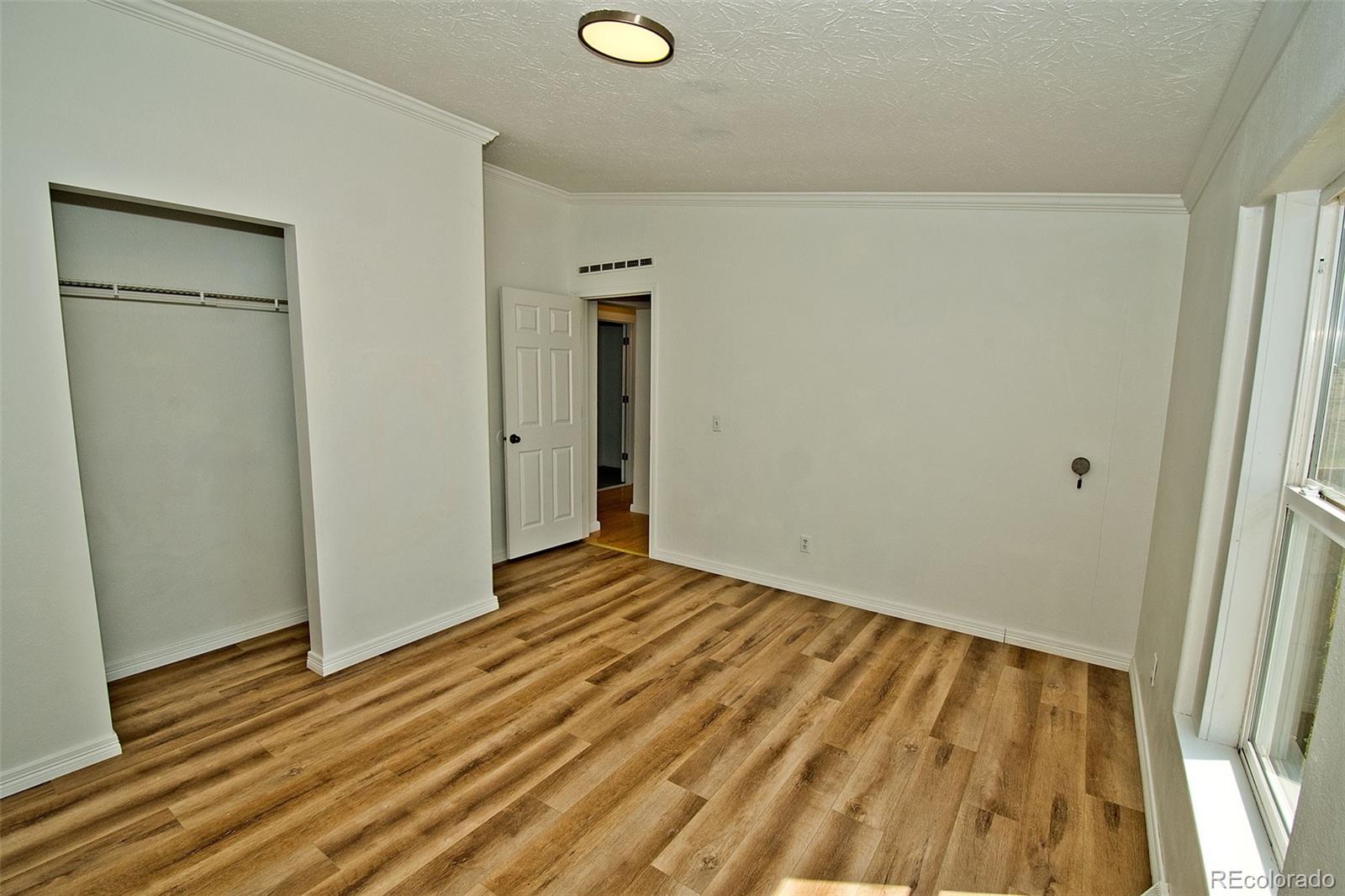 1372 North Saddlerock Trail Crestone, CO 81131 - Photo 42 of 43 a view of an empty room with wooden floor and a window