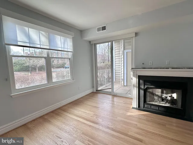 a room with a fireplace wooden floor and windows