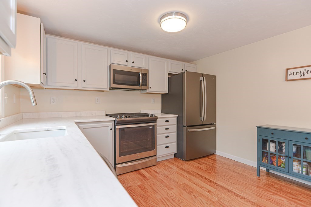 41 Boston Road, Unit 351 Billerica, MA 01862 - Photo 5 of 25 a kitchen with stainless steel appliances granite countertop a refrigerator stove and sink