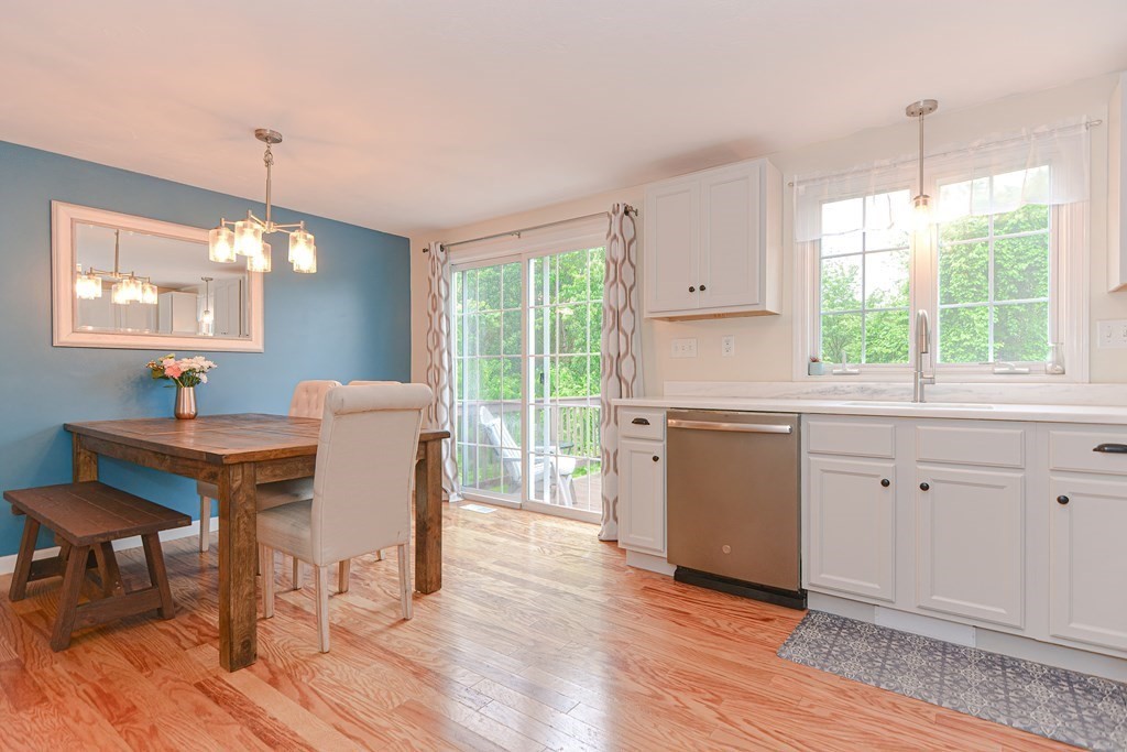 41 Boston Road, Unit 351 Billerica, MA 01862 - Photo 6 of 25 a kitchen with a table chairs a sink dishwasher window and wooden floor