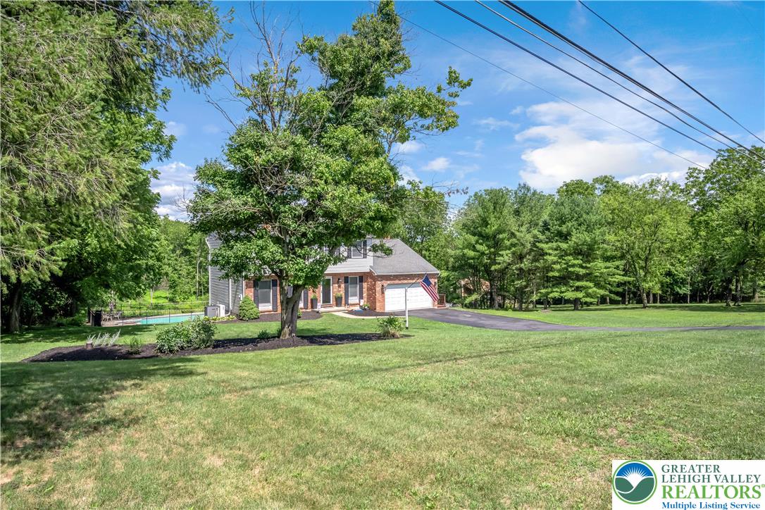 2448 Keeler Road Bath, PA 18014 - Photo 3 of 37 A classic brick-front residence with an inviting swimming pool, nestled among mature trees on a sprawling green lot.