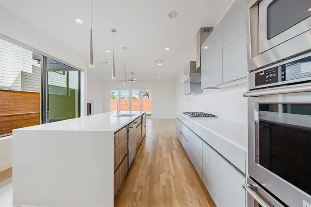 a large kitchen with stainless steel appliances granite countertop a stove a sink and a refrigerator