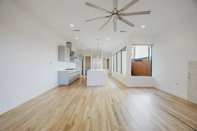 a view of a big room with wooden floor and windows
