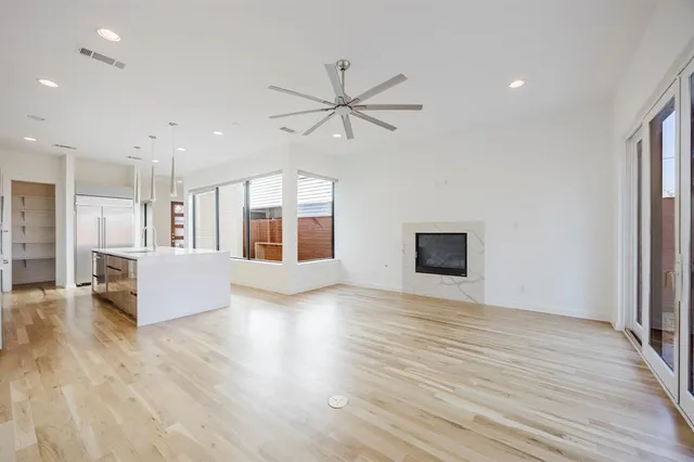 a view of an empty room with window and wooden floor