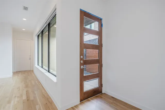 a view of a hallway with wooden floor and entryway