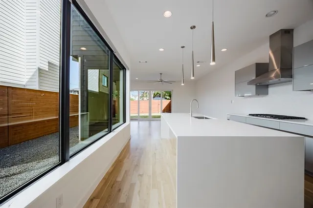 a kitchen with stainless steel appliances a sink stove and a large window