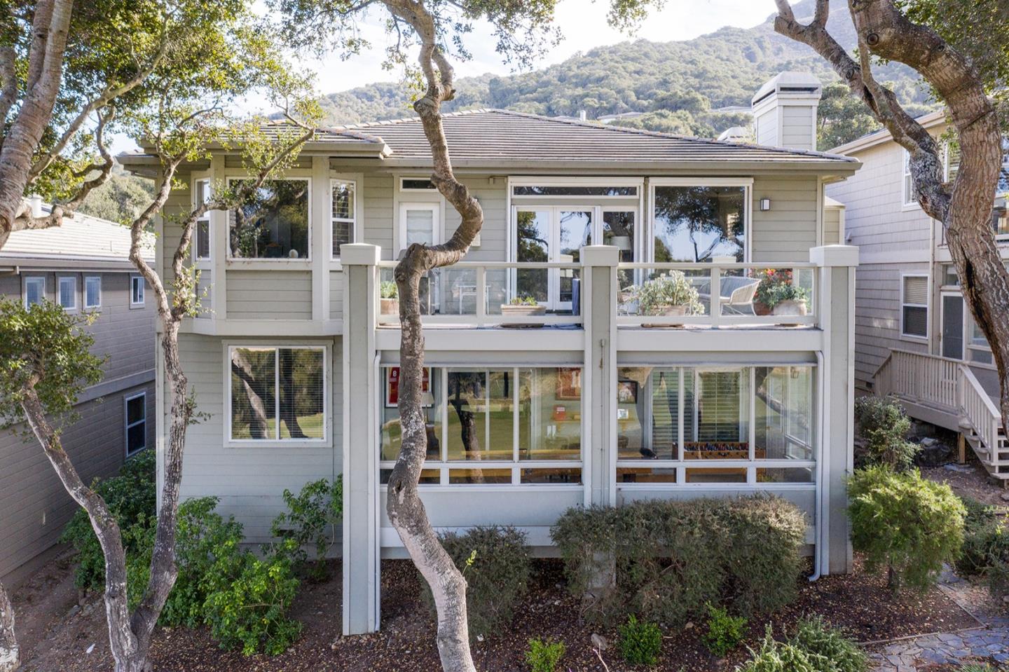 10483 Fairway Lane Carmel, CA 93923 - Photo 2 of 3 a view of a brick house with large windows and a large tree