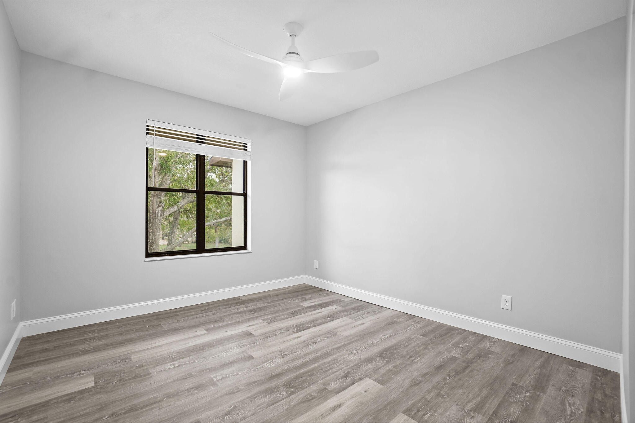 250 Southeast Four Winds Drive, Unit 204 Stuart, FL 34996 - Photo 16 of 32 an empty room with wooden floor and windows