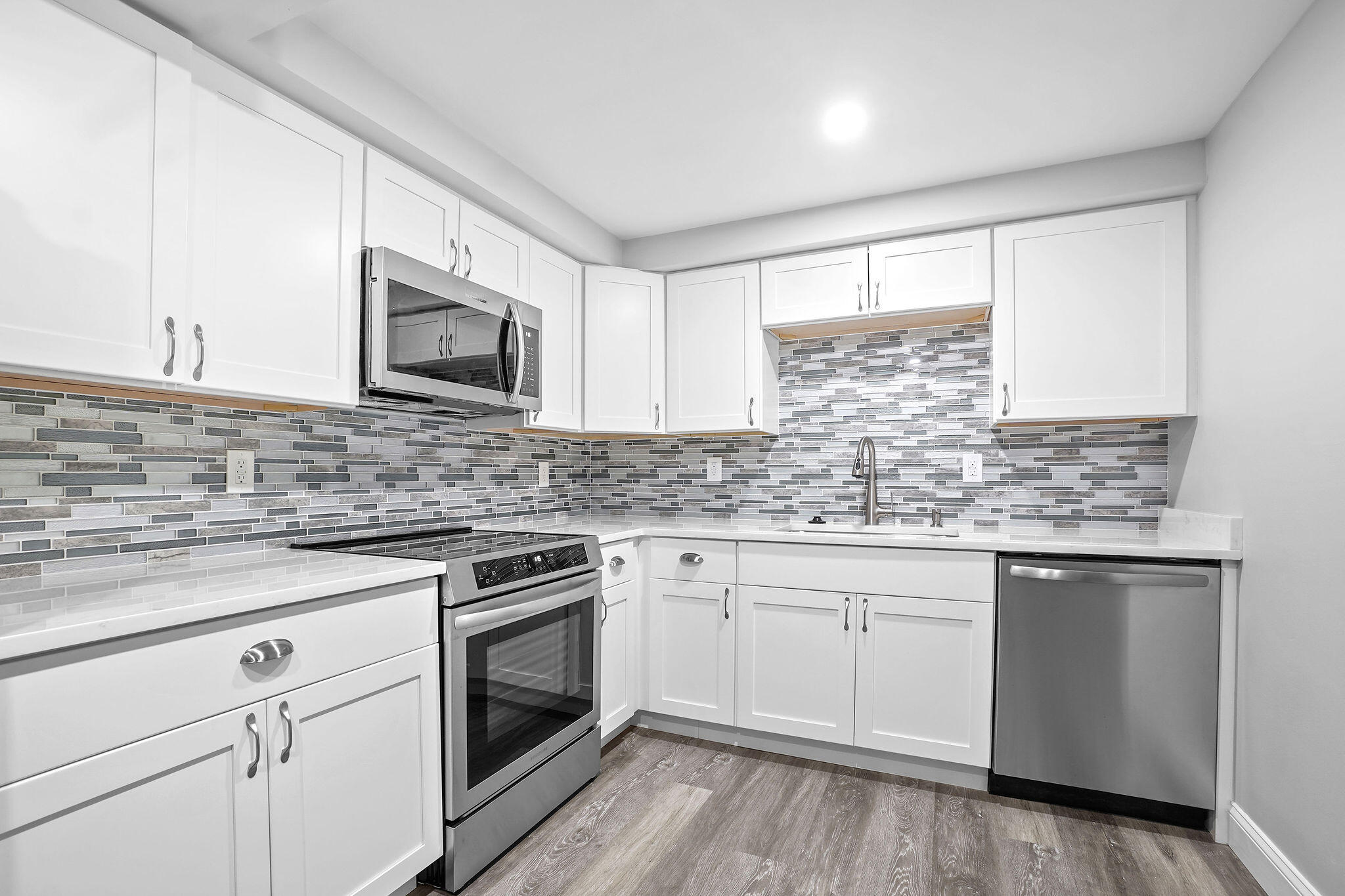 250 Southeast Four Winds Drive, Unit 204 Stuart, FL 34996 - Photo 2 of 32 a kitchen with granite countertop white cabinets stainless steel appliances a sink and a window
