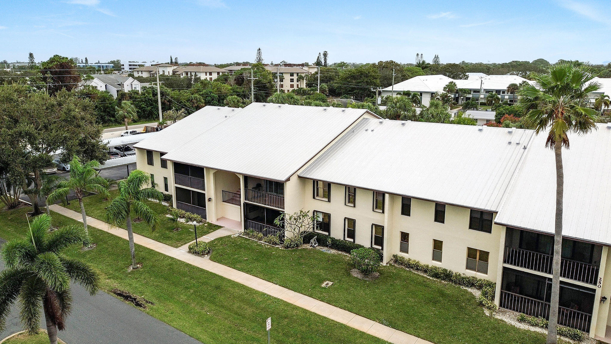 250 Southeast Four Winds Drive, Unit 204 Stuart, FL 34996 - Photo 28 of 32 a view of a white house with a big yard plants and large trees