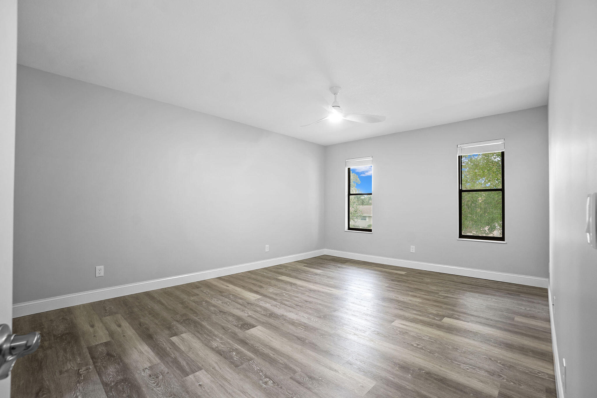 250 Southeast Four Winds Drive, Unit 204 Stuart, FL 34996 - Photo 9 of 32 an empty room with wooden floor and windows