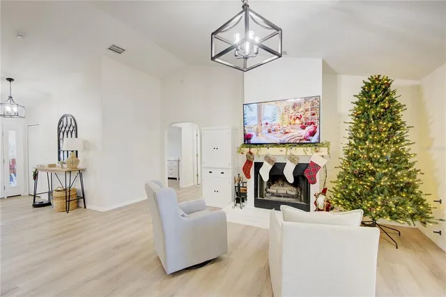 a living room with furniture kitchen and a chandelier