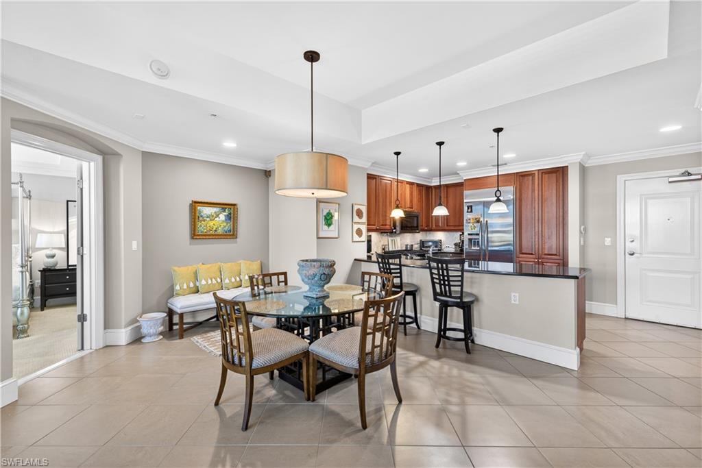 9115 Strada Place, Unit 5504 Naples, FL 34108 - Photo 5 of 22 a view of a dining room and livingroom with furniture wooden floor a chandelier