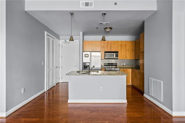 a view of a kitchen with kitchen island a counter top space appliances and cabinets