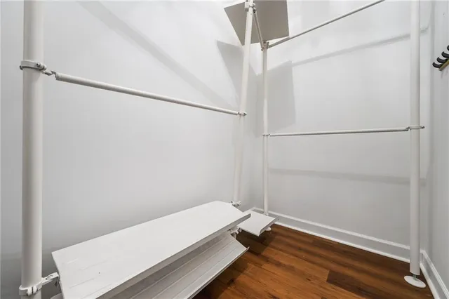 a room with a white bed and a wooden floor