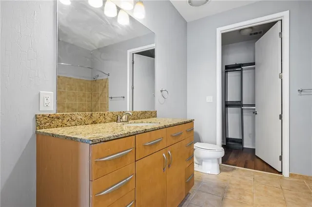 a bathroom with a granite countertop sink toilet and shower