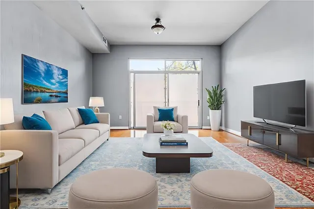 a living room with furniture a flat screen tv and a large window