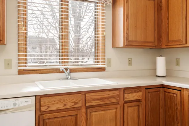 a kitchen with granite countertop a sink window and cabinets