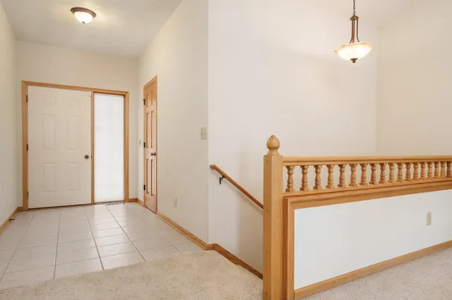 a view of an empty room with a fireplace and a ceiling fan