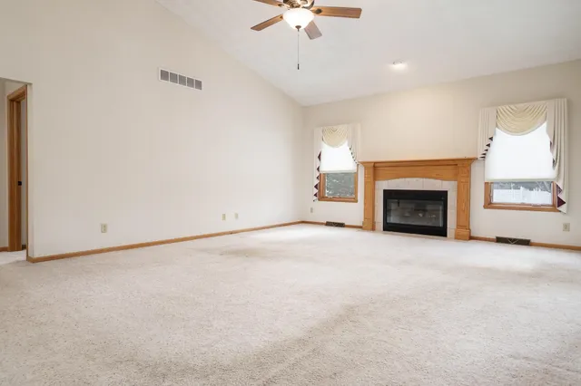 an empty room with windows and fireplace
