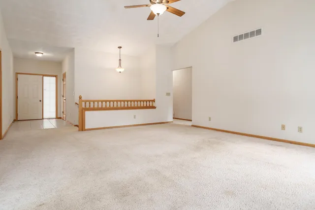 an empty room with fan and windows