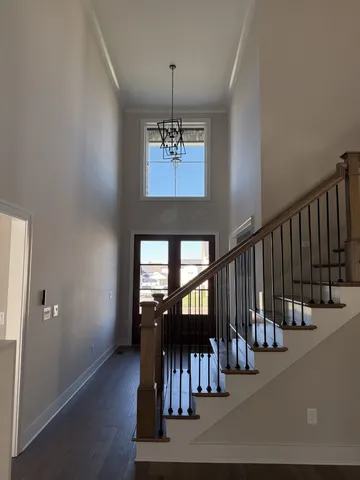 a view of a hallway with wooden floor and stairs