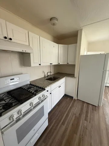 a kitchen with granite countertop a stove and a refrigerator