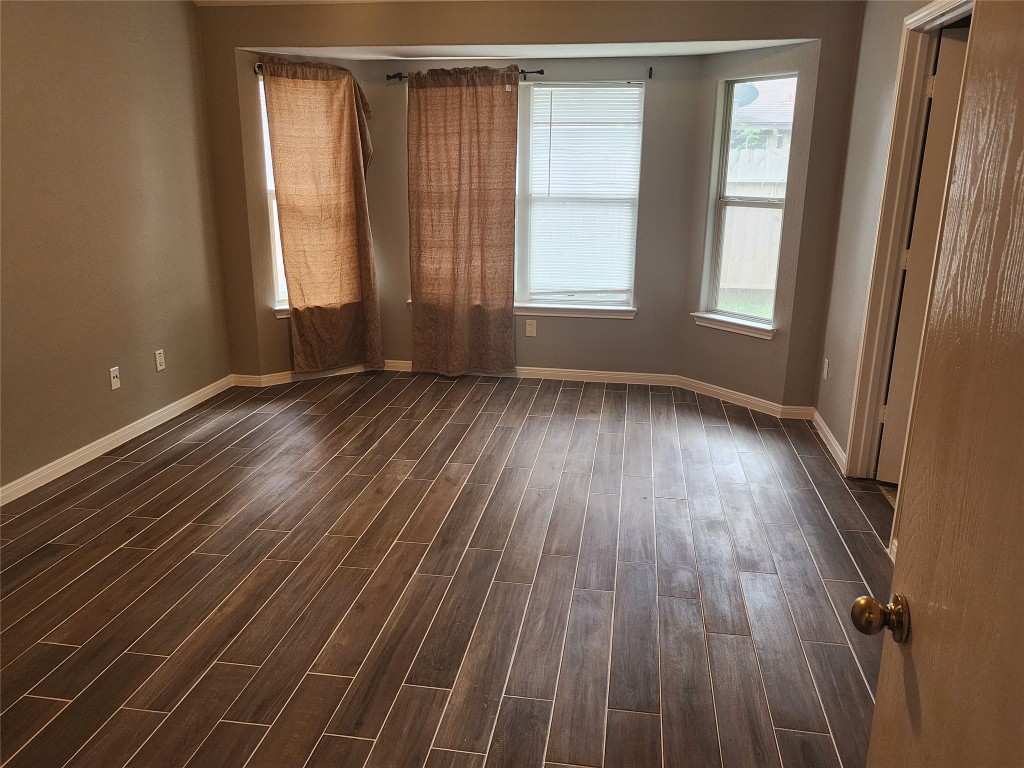 23107 Kimberly Glen Lane Spring, TX 77373 - Photo 5 of 8 an empty room with wooden floor and windows