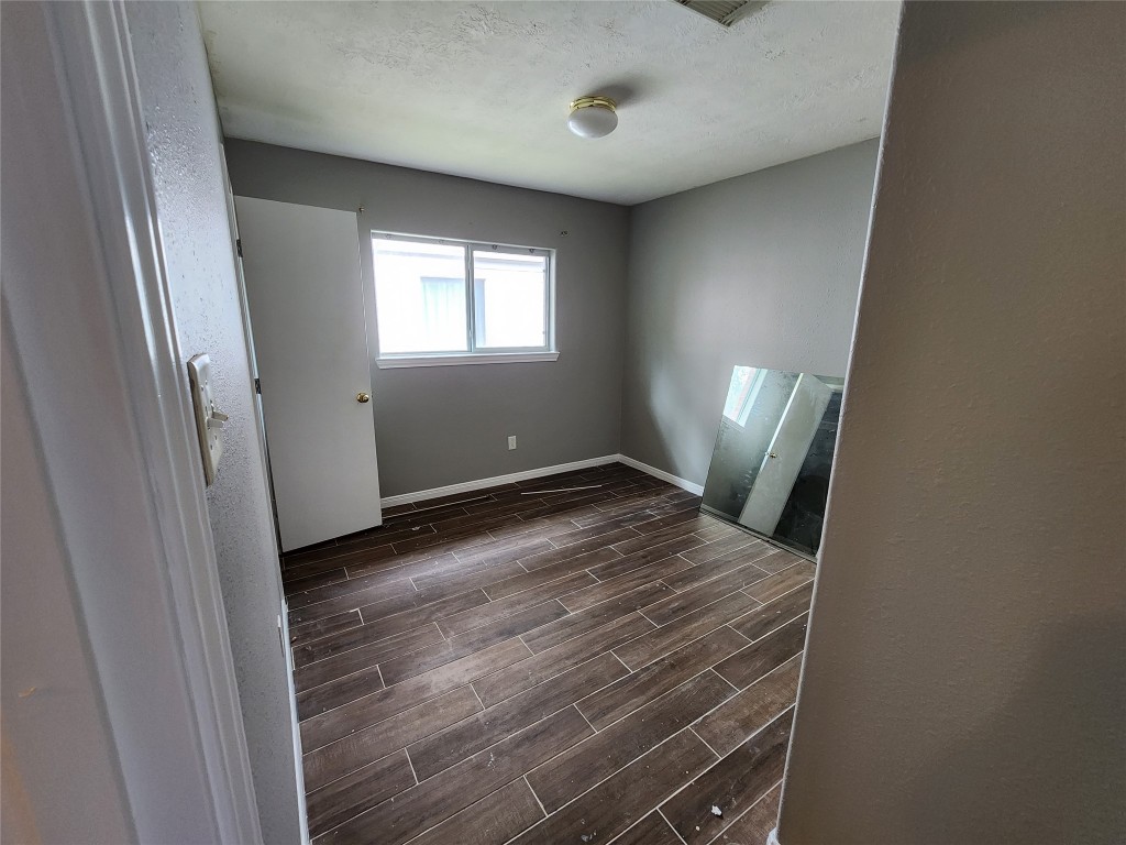 23107 Kimberly Glen Lane Spring, TX 77373 - Photo 7 of 8 a view of an empty room with wooden floor and a window