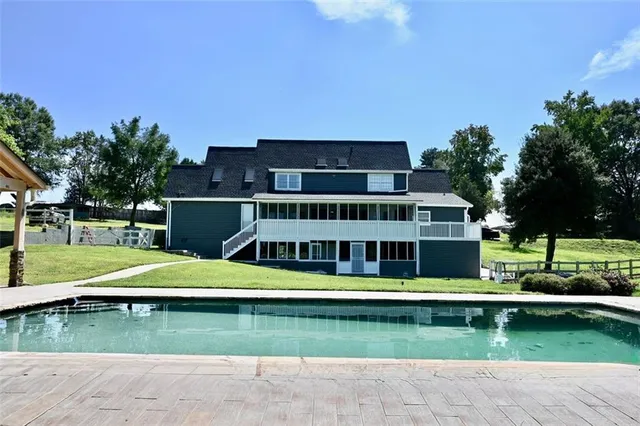 a kitchen with granite countertop a refrigerator sink and white cabinets