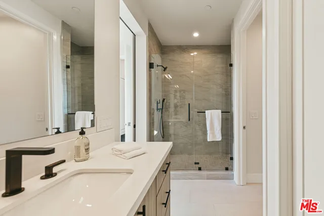 a bathroom with a shower sink and mirror