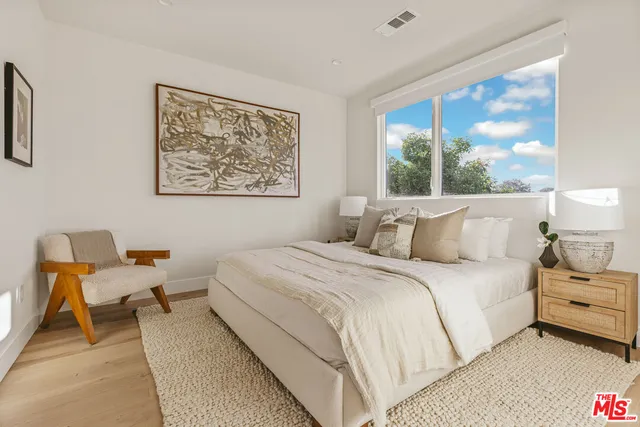 a bedroom with bed and a large window
