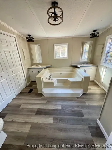 a view of an empty room with wooden floor and entrance