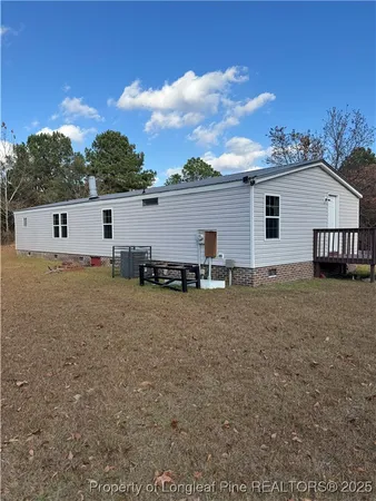 a view of a house with backyard and trees